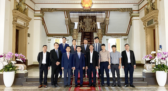 Ha Suk-joo, CEO of Lotte Engineering & Construction, fourth from left in first row, and Ho Chi Minh City People's Committee Chairman Phan Van Mai, fifth from left in first row, pose for a photo after signing an agreement to partner on the construction of Thu Thiem Eco City, on May 13. [LOTTE ENGINEERING & CONSTRUCTION]