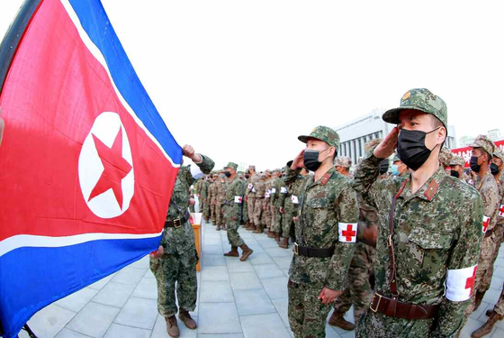 In this photo by the state-run Rodong Sinmun, North Korea soldiers salute the flag. The Korean Central News Agency reported that the country's military would be deployed to ensure a stable and continuous distribution of medicine through pharmacies to combat the country's Covid-19 outbreak. [YONHAP] 