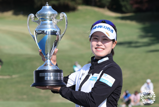 Park Min-ji holds up the NH Investment & Securities Ladies Championship trophy on Sunday after defending her 2021 title at Suwon Country Club in Yongin, Gyeonggi. [KLPGA]