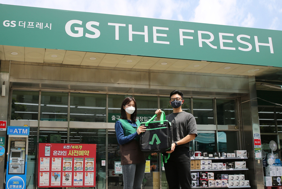 Models pose in front of a GS The Fresh discount store branch, which is used as a micro-fulfillment center for Yogiyo's quick commerce deliveries. [GS RETAIL]