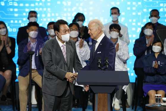 President Yoon Suk-yeol, left, shakes hands with U.S. President Joe Biden on Friday at a Samsung Electronics chip complex in Pyeongtaek, Gyeonggi. [JOINT PRESS CORPS.]