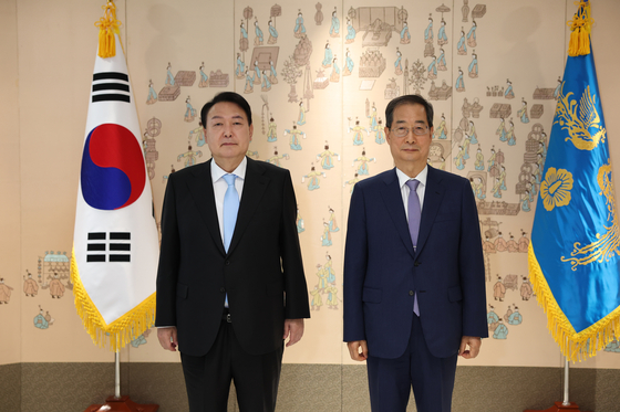 Prime Minister Han Duck-soo, right, stands beside President Yoon Suk-yeol at the presidential office in Yongsan District, central Seoul following his appointment to the post on Saturday morning. [NEWS1]