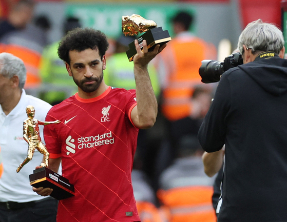 Liverpool's Mo Salah holds the Premier League's Playmaker and Golden Boot trophies after a match against Wolverhampton Wanderers at Anfield in Liverpool on Sunday. [REUTERS/YONHAP]