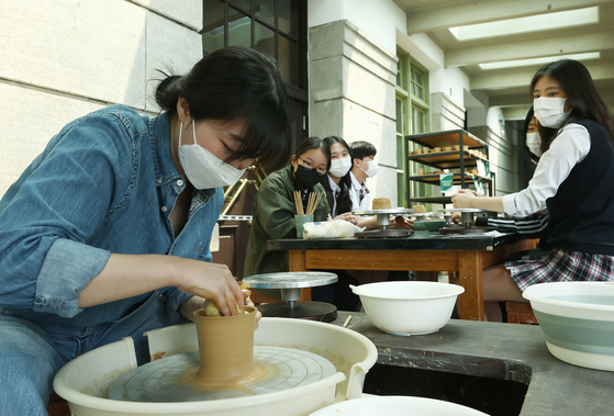 A visitor makes her own celadon cup in one of the programs for Craft Week 2022. [YONHAP]