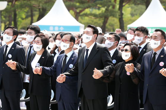 President Yoon Suk-yeol, center, sings "March for the Beloved" in a ceremony marking the 42nd anniversary of the May 18 Democratization Movement at the national cemetery in Gwangju Wednesday. [YONHAP]