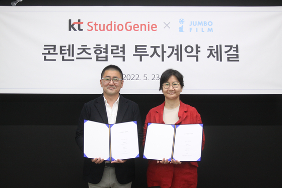 KT Studio Genie CEO Kim Chul-yeon, right, and Jumbo Film Director Han Dong-hwa stand for photos after the KT subsidiary agreed to buy a 30 percent stake in the drama production company on Monday. [KT]