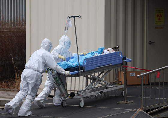 A medical team moving in a Covid-19 patient in critical condition at a hospital in Seoul in March. [YONHAP]