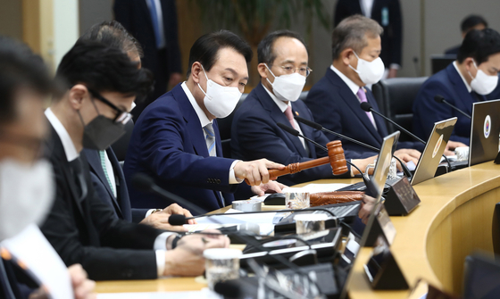 President Yoon Suk-yeol, center, bangs a gavel as he convenes his first Cabinet meeting at the Sejong government complex in Sejong City Thursday. [NEWS1]