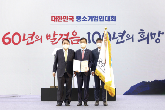 The Export-Import Bank of Korea (Kexim) received a presidential citation for its dedication to nurturing small- and medium-sized enterprises (SMEs) during an event that emphasized the importance of collaboration between big corporations and SMEs held in Yongsan, central Seoul, on Wednesday. President Yoon Suk-yeol, left, and chairman and president of Kexim Bang Moon-kyu, center, stand for a photo at the award ceremony. The bank dedicated 30.3 trillion won ($23.9 billion) for the growth of local SMEs last year, the highest ever and 45 percent more than the 20.9 trillion won dedicated 10 years ago. During the same period, the export volume of Korean SMEs increased by 30 percent to stand at $228.4 billion, according to Kexim. It was the only financial institute to receive the citation. [KEXIM]