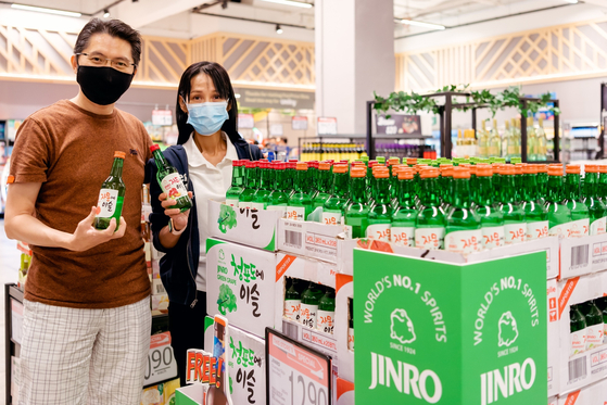 Models promote HiteJinro's fruit-flavored soju at a discount mart in Singapore. [HITEJINRO] 