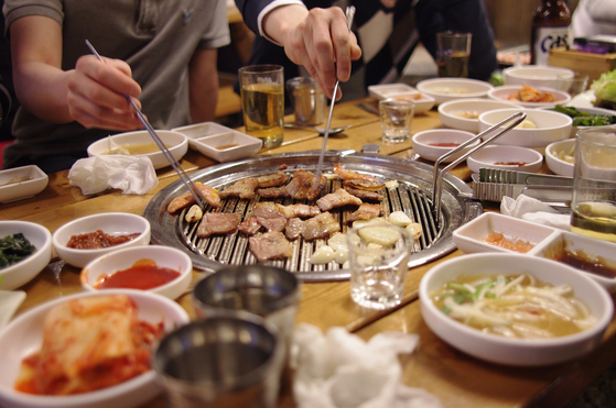People drink soju with samgyeopsal, or sliced pork belly. [PIXABAY]