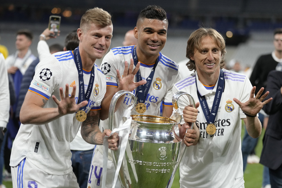 From right to left, Real Madrid's Toni Kroos, Casemiro and Luka Modric pose for a photograph with the trophy after winning the Champions League final against Liverpool at the Stade de France in Paris on Saturday. Real Madrid defeated Liverpool 1-0. [AP/YONHAP]