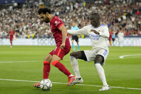 Liverpool's Mohamed Salah, left, controls the ball next to Real Madrid's Ferland Mendy during the Champions League final match between the two clubs at the Stade de France in Paris on Saturday. [AP/YONHAP]