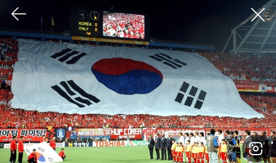 The Korean national flag, the Taeguekgi, is held by fans during the 2002 World Cup. [YOO YOUNG-WOON]