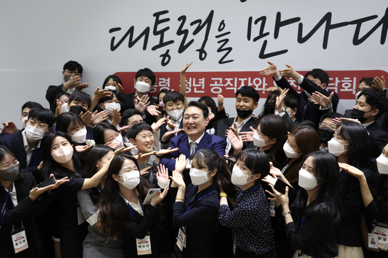 President Yoon Suk-yeol, center, poses for a commemorative photo with young officials at the Sejong government complex in Sejong Thursday. [YONHAP]