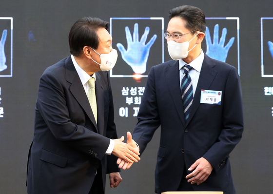 Samsung Electronics Vice Chairman Lee Jae-yong, right, shakes hands with President Yoon Suk-yeol during an event on May 25 at the presidential office in Yongsan, central Seoul. [JOINT PRESS CORPS.]