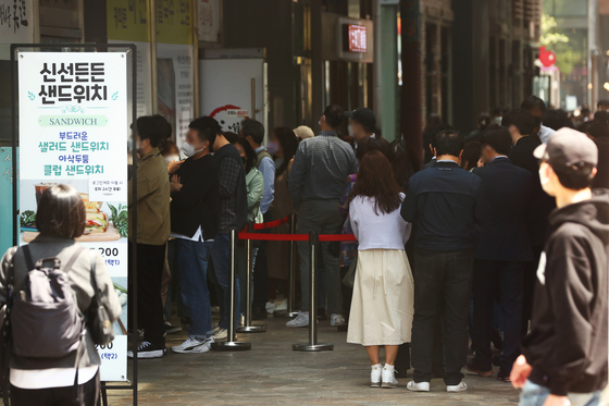 Customers wait in line at a restaurant in Jongno District, central Seoul at lunchtime on April 20, two days after most social distancing restrictions were lifted in the country. [YONHAP] 