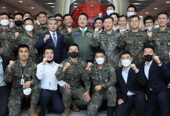 President Yoon Suk-yeol, center, poses with defense and Joint Chiefs of Staff officials during his Monday morning visit to the Defense Ministry's relocated headquarters in Yongsan District, central Seoul. [YONHAP]