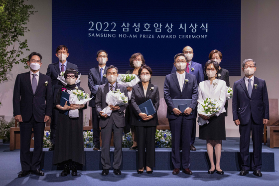 Recipients of the Samsung Ho-Am Prize Award pose with Samsung Electronics Vice Chairman Lee Jae-yong, far left front row, during a ceremony held at the Shilla Hotel in Seoul on Tuesday. From front row second from left: Poet Kim Hye-soon, who received the award in the arts category; Heart to Heart Foundation president Oh Jee-chul and board chairwoman Shin In-sook, who won for community service; Seoul National University professor and Data Science graduate school founding dean Cha Sang-kyun and his wife, who won in the engineering category; Ho-Am Foundation Chairman Kim Hwang-sik; second row from left: KAIST organic chemistry professor Chang Suk-bok, who won for chemistry and life sciences; Postech mathematics professor Oh Yong-geun and his wife, who won in physics and mathematics; and Harvard Medical School pathology professor Keith Joung and his wife, who won for medicine. The foundation recognizes those who have contributed to society and humanity. The recipients receive a 187.5-gram gold medal and a cash prize of 300 million won ($275,000).  