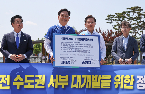 Lee Jae-myung, center right, Democratic Party (DP) candidate for Incheon's Gyeyang-B district, and Song Young-gil, center left, DP’s Seoul mayor candidate, pledge to shut down Gimpo airport for the redevelopment of the area in a press conference in Gimpo, Gyeonggi, Friday. [NEWS1]