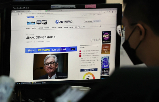 A foreign exchange dealer reads news covering the announcements made by the Federal Reserve Chair Jerome Powell at Hana Bank in central Seoul on May 6. [YONHAP]
