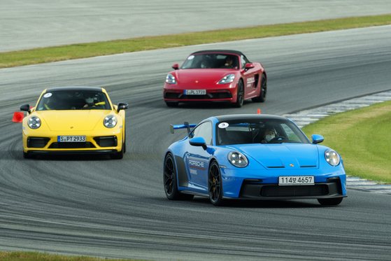 Porsche cars on a race track with the 911 GT3 in front [PORSCHE KOREA]
