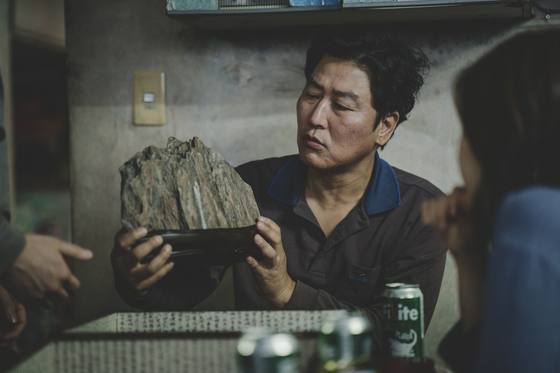 Song portrays Ki-taek in “Parasite” (2019), the father of the Kim family who live in a small semi-basement apartment in Seoul. He and the rest of the family end up working for the wealthy Park family. [CJ ENM]