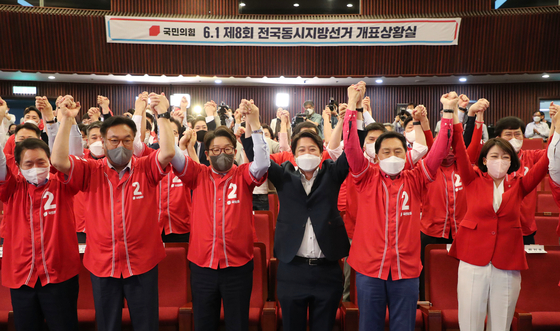 Lee Jun-seok, center right, chairman of the People Power Party (PPP), and other party officials cheer as they hear the results of the June 1 local elections and by-elections from a situation room in the National Assembly in Yeouido, western Seoul, Wednesday night. [JOINT PRESS CORPS]