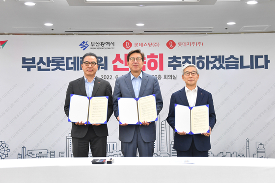 From left: Lotte Shopping CEO Jung Jun-ho, Busan Mayor Park Heong-joon and Lotte Corporation CEO Song Yong-dok pose for a photo after signing a memorandum of understanding Thursday at Busan City Hall. [BUSAN METROPOLITAN CITY]