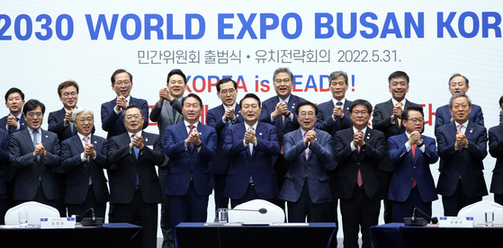 President Yoon Suk-yeol, front row center, poses for a photo with SK Group Chairman Chey Tae-won and other business executives and officials to launch a committee supporting Busan’s bid for the 2030 World Expo at Busan Port International Exhibition & Convention Center Tuesday. [YONHAP]