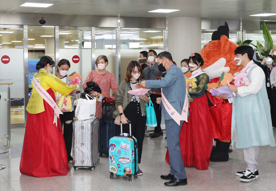 Employees from Jeju Tourism Organization greet travelers coming from Bangkok via a Jeju Air flight at Jeju International Airport on Friday. [NEWS1]