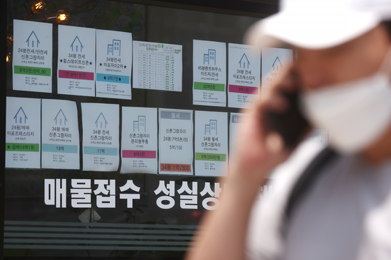 Notices of apartments for sale are posted on a window at a realtor's office in Seoul. The number of monthly rentals were more than half of the total lease contracts in the country in April for the first time, according to the Ministry of Land, Infrastructure and Transport. [YONHAP]
