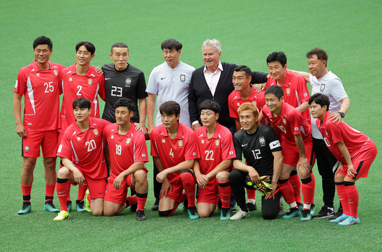 The Korean Legends football team poses for a photo with Korea's head coach from the 2002 World Cup Guus Hiddink, center, ahead of a match against the Korean national U-14 squad on Sunday on an auxiliary pitch at Seoul World Cup Stadium in Mapo District, western Seoul. [YONHAP]