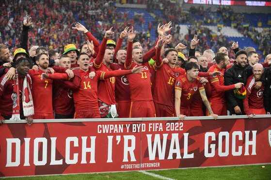 The Welsh football team celebrates after beating Ukraine 1-0 to earn a spot at the 2022 Qatar World Cup. [REUTERS/YONHAP]