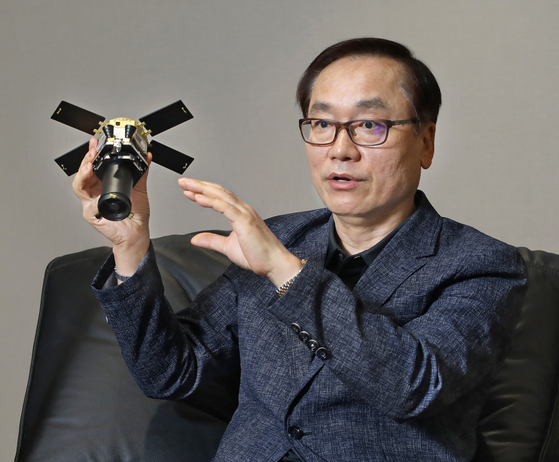 Hanwha Aerospace CEO Shin Hyun-woo speaks during an interview on May 23 in central Seoul while holding a minature satellite. [PARK SANG-MOON]