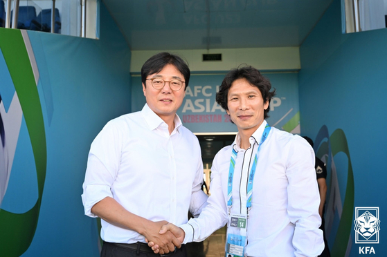 Left, head coach of the Korean U-23 team Hwang Sun-hong poses for a picture with head coach of the Vietnam U-23 team Gong Oh-kyun at Lokomotiv Stadium in Tashkent, Uzbekistan on Sunday. [NEWS1]