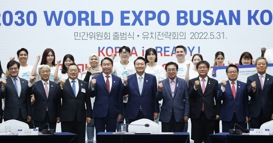 President Yoon Suk-yeol, front row center, poses for a photo with SK Group Chairman Chey Tae-won and other business executives and offi cials to launch a committee supporting Busan’s bid for the 2030 World Expo at Busan Port International Exhibition & Convention Center Tuesday. [YONHAP]