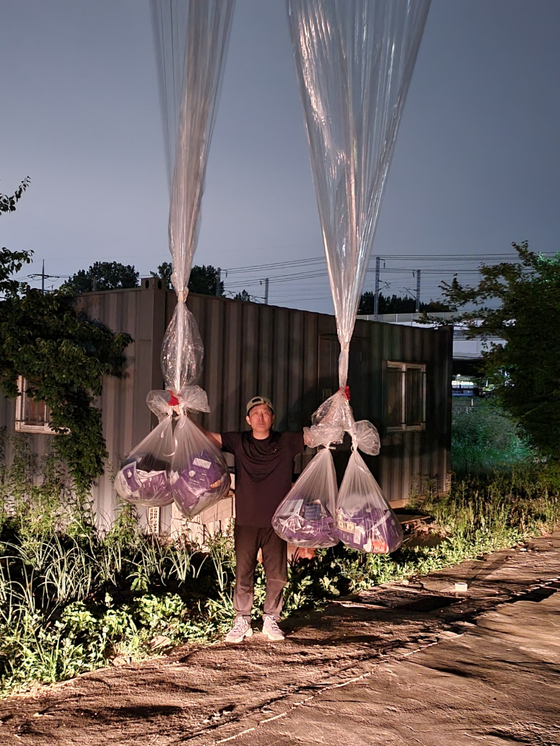 Park Sang-hak, head of Fighters for a Free North Korea, an organization of North Korean defectors, holds balloons filled with medicine before launching them near the inter-Korean border in Pocheon, Gyeonggi, on Sunday. [FIGHTERS FOR A FREE NORTH KOREA] 