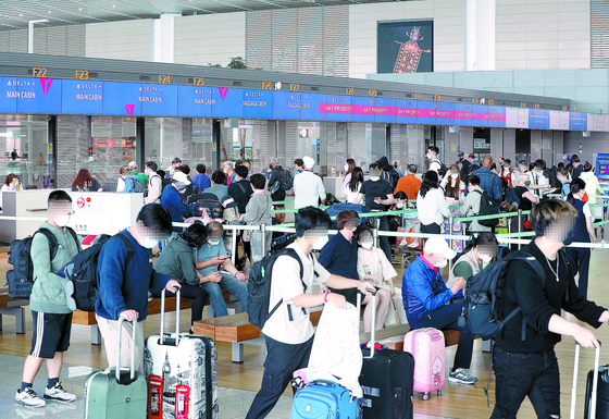 Demand for summer camps, some abroad, skyrocketed after they reopened for the first time in two years. In this photo, travelers line up in the departure lobby of Terminal 2 at Incheon International Airport on Sunday afternoon. [YONHAP]