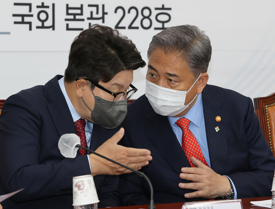 PPP chief whip Kwon Seong-dong, left, talks to Foreign Minister Park Jin during a party-government meeting at the National Assembly on Wednesday. [JOINT PRESS CORPS]