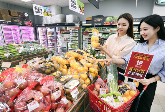 Homeplus Express supermarkets will be holding various discount promotions from June 9 to 22 in commemoration of the chain's 18th anniversary. Models promote the event at the Homeplus Express Gangseo branch in western Seoul on Wednesday. [YONHAP]