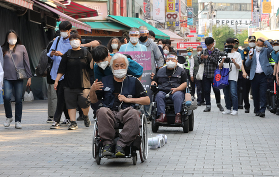 Park Kyung-seok, a representative of the Solidarity Against Disability Discrimination (SADD), and activists head toward the Seoul Metropolitan Council from Hoehyeon Station in central Seoul on June 2. [NEWS1]