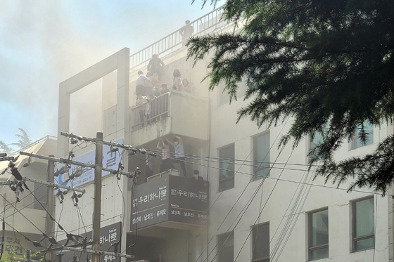This photo contributed by a news reader shows citizens waiting for help on the terraces of a building on fire in Daegu on Thursday. [YONHAP]