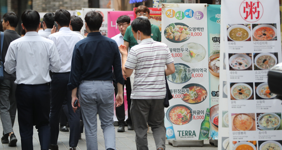 People walk past restaurants in Myeongdong, central Seoul on Wednesday. [NEWS1]