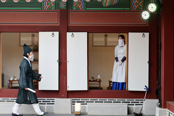 Officials at the Gyeongbok Palace dressed as palace courtesans wait to greet participants to Sojubang, Gyeongbok Palace's royal kitchen for the “Invitation to Gyeongbok Palace’s Kitchen: Suragan Sisikgonggam″ program organized by the Cultural Heritage Administration and the Korea Cultural Heritage Foundation. [YONHAP]