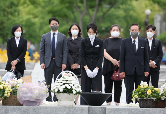 First lady Kim Keon-hee, center, pays her respects at the grave of President Roh Moo-hyun in Bongha Village, Gimhae, in South Gyeongsang on Monday. She later visited Kwon Yang-sook, Roh's widow. [YONHAP]