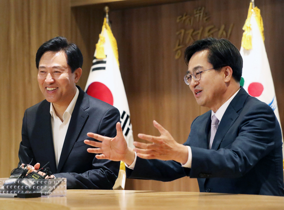 Seoul Mayor Oh Se-hoon of the People Power Party, left, talks to Gyeonggi Governor-elect Kim Dong-yeon of the Democratic Party at Seoul City Hall in Jung District, central Seoul. The two leaders discussed the extension of regional bus and subway hours. [NEWS1]