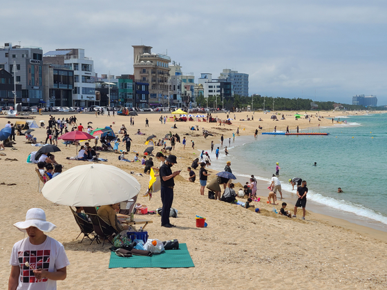 Visitors to Anmok Beach in Gangneung, Gangwon, enjoy an early summer vacation on Sunday, weeks before nationwide beaches normally open to the public for the first time in three years. [PARK JIN-HO]