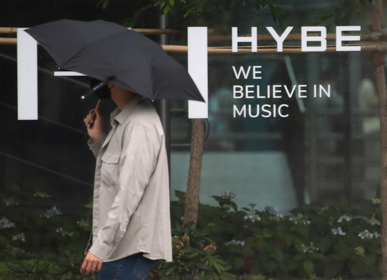 A pedestrian passes by HYBE headquarters in Yongsan, central Seoul, Wednesday. Shares of HYBE plummeted after the band announced that it will be taking a break as a group Tuesday night. [NEWS1]