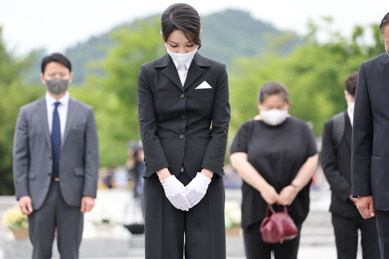First lady Kim Keon-hee, center, pays her respects at the grave of President Roh Moo-hyun in Bongha Village, Gimhae, in South Gyeongsang on Monday. She is accompanied by a woman, right, who was later identified as a professor and close acquaintance of Kim. [YONHAP]